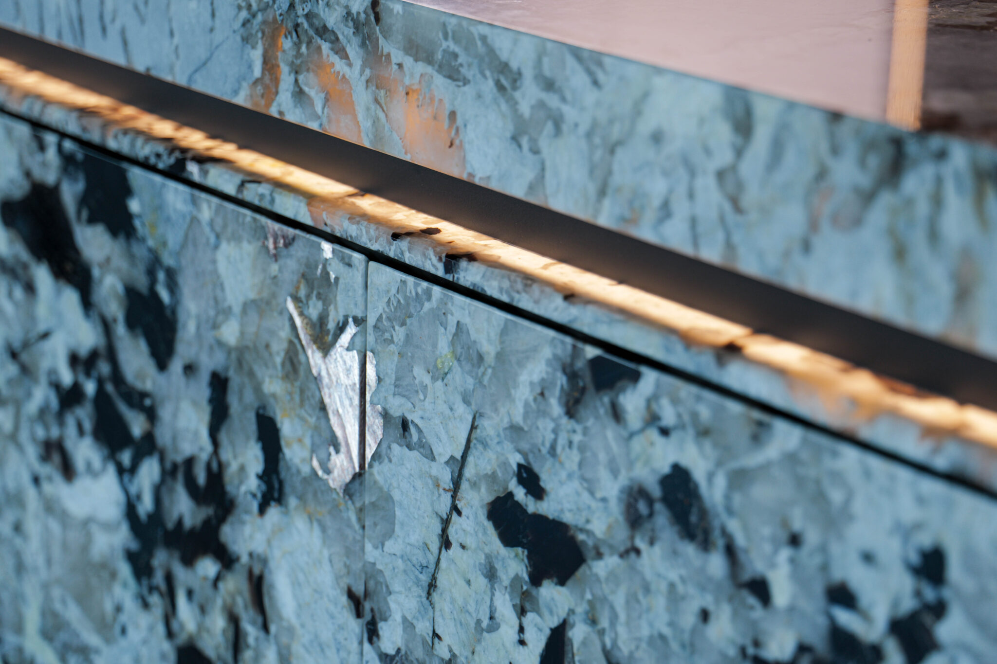Custom natural stone kitchen island by KAMICO with precisely finished edges and contemporary cabinetry